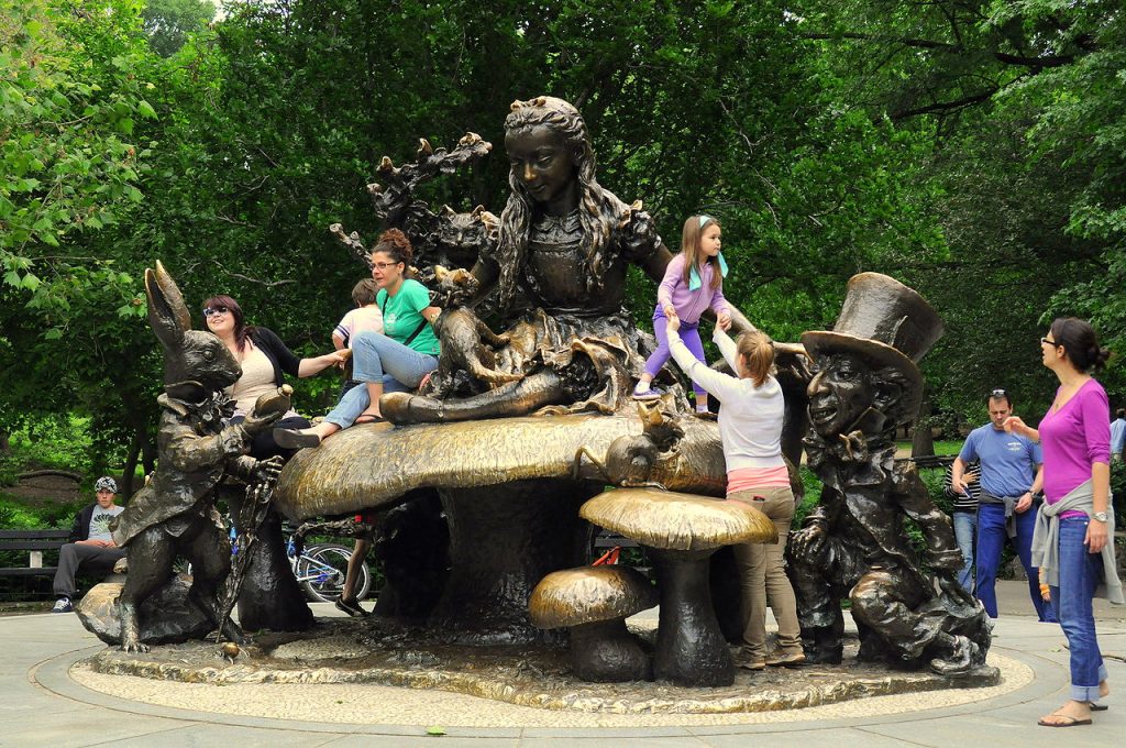 Family-Friendly NYC: Children play on Jose de Creeft's sculpture 'Alice in Wonderland' in Central Park, New York